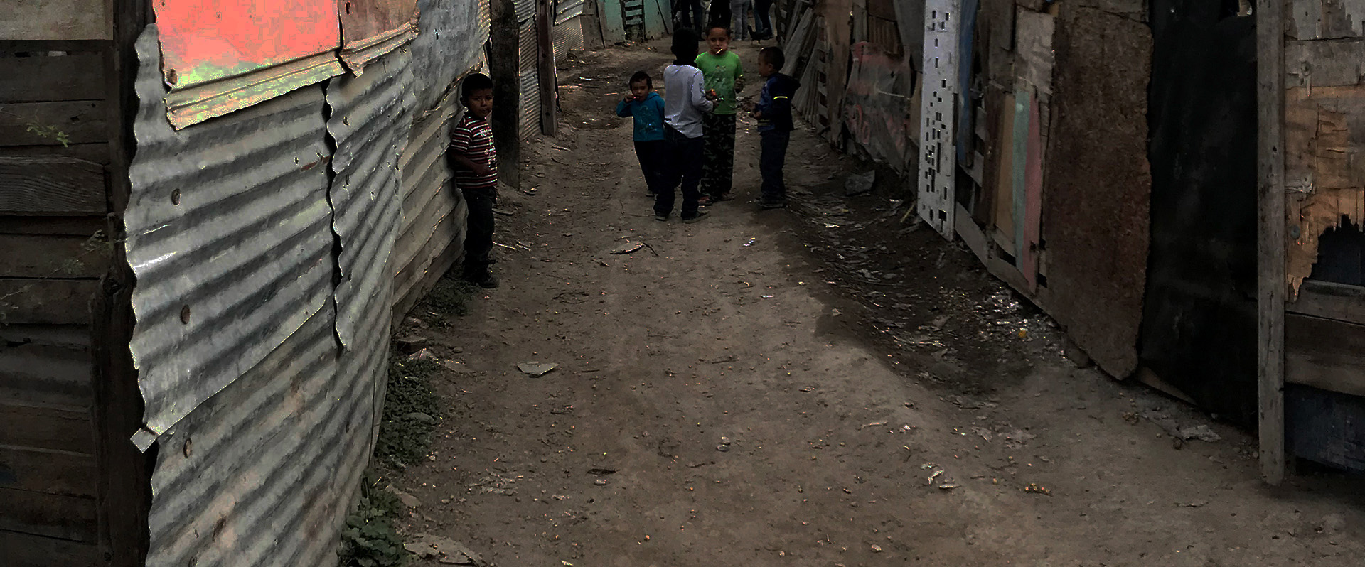Boys in street between shacks